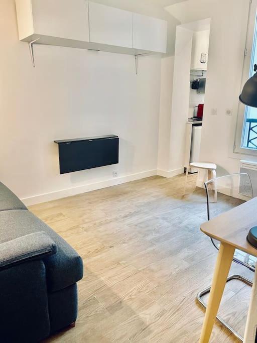 un salon avec un canapé et une télévision à écran plat dans l'établissement In the center of Montmartre, à Paris