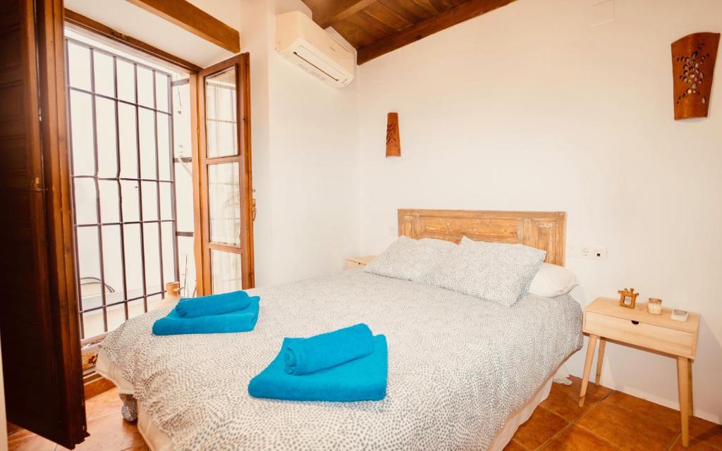 Un dormitorio con una cama con almohadas azules. en PRECIOSO DúPLEX PLAZA NUEVA, en Granada