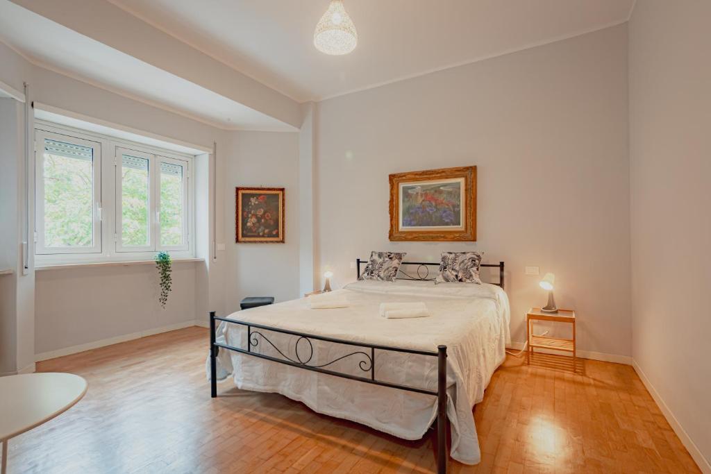 une chambre blanche avec un grand lit dedans dans l'établissement La Chiocciola, à Lido di Ostia