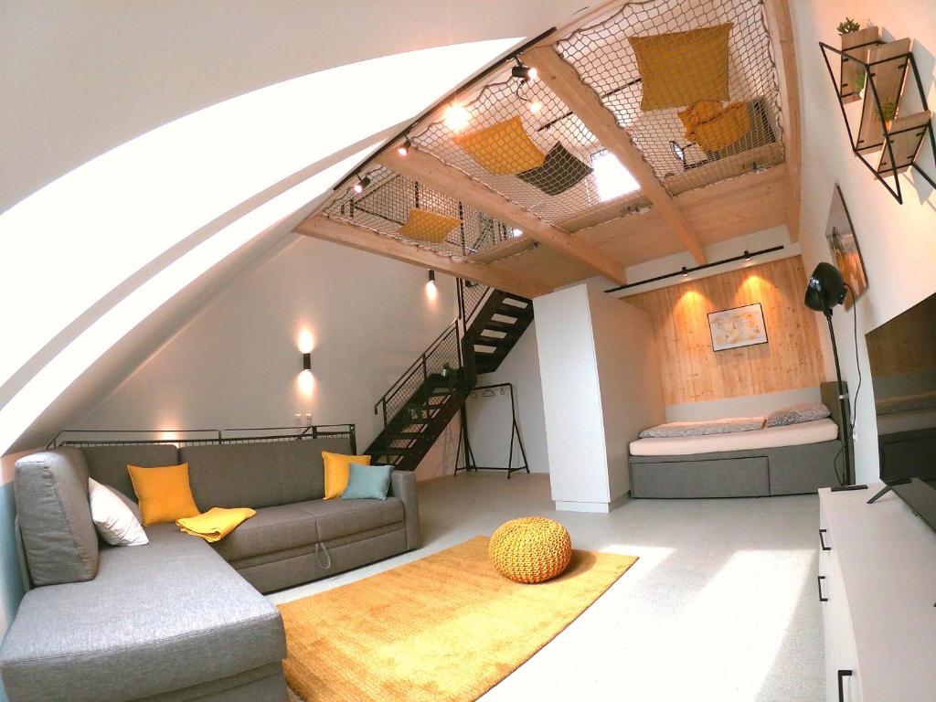 Una sala de estar con un sofá y un loft. en miniLOFT apartments Linz, en Linz