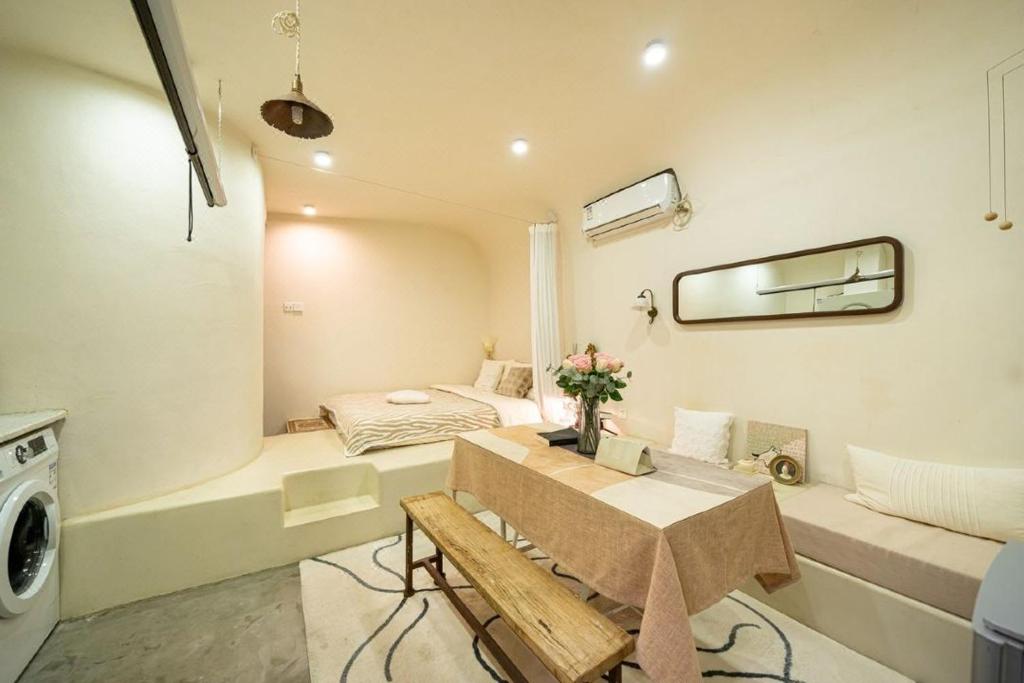 una pequeña sala de estar con cama y mesa. en Shanghai Hills & Well-time Homestay en Shanghái