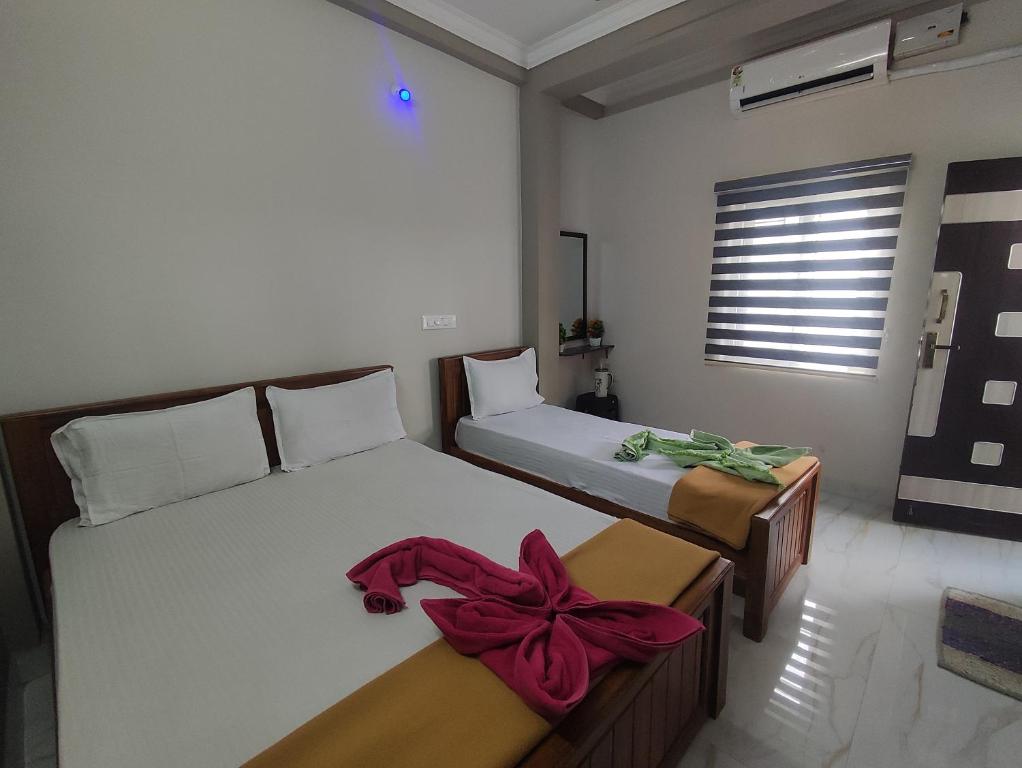 a bedroom with two beds with bows on them at Sri Aksha Residency in Alāndurai