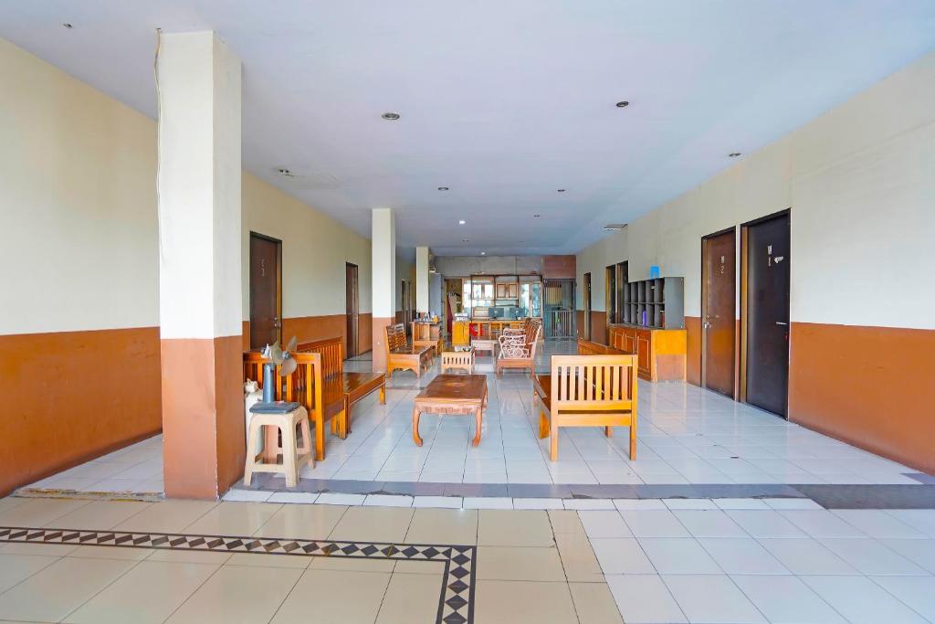 a hallway with chairs and tables in a building at OYO 91415 De Wijaya Hotel in Bungurasih