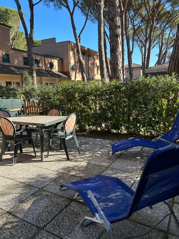 patio con tavolo e sedie su un marciapiede di Bilocale con giardino a Marina di Grosseto