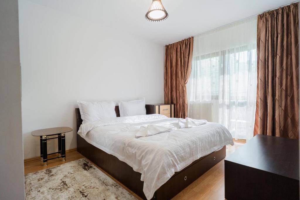 a bedroom with a large bed and a window at Renovated Gem Plumbuita Park in Bucharest