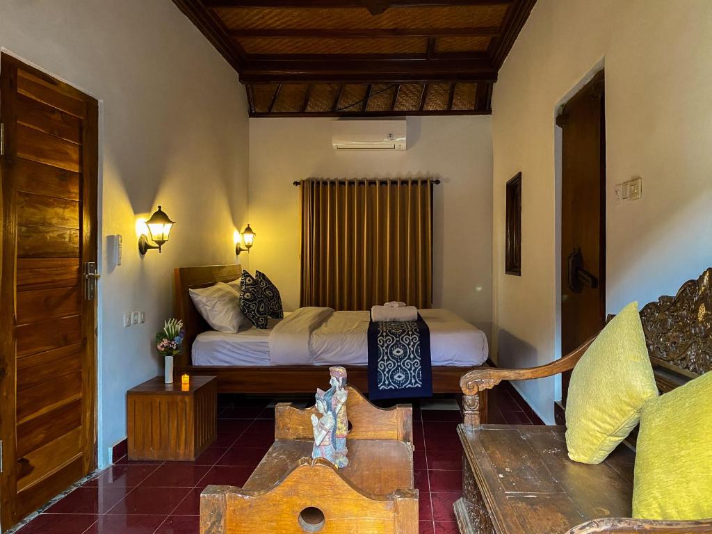 1 dormitorio con 1 cama y 1 sofá en una habitación en TM DARTA Homestay UBUD, en Ubud