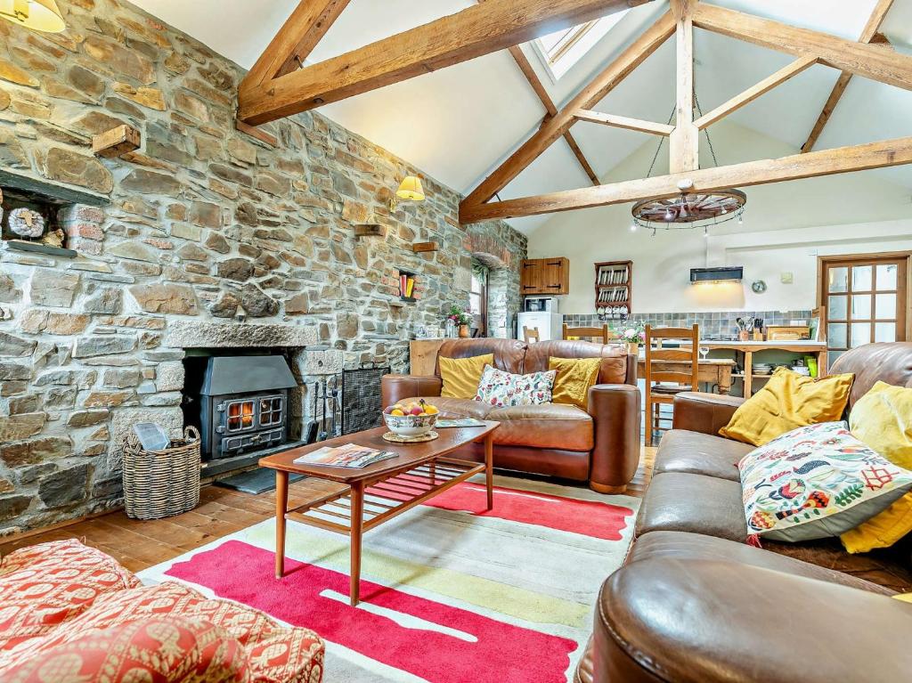 una sala de estar con sofás y una chimenea de piedra. en 2 Bed in Crackington Haven 02033 en North Petherwin