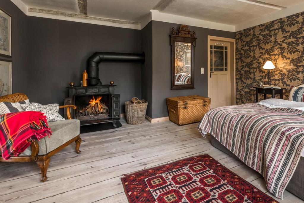a bedroom with a bed and a fireplace at Pommernhaus Charmantes Colonistenhaus, Kamin, Ruderboot in Vorsee
