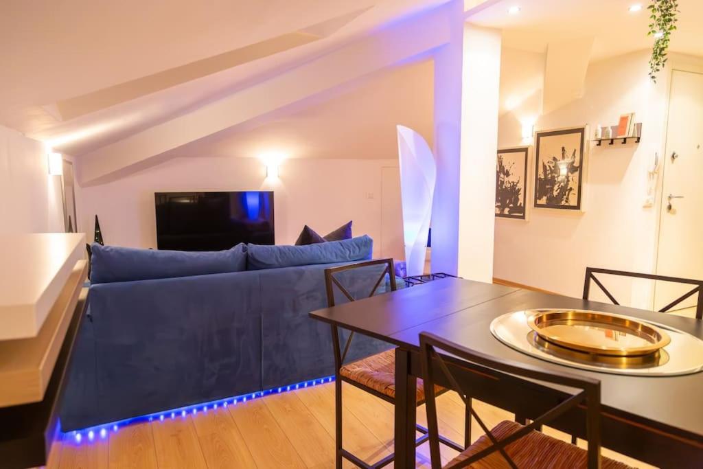 een woonkamer met een blauwe bank en een tafel bij LA MANSARDA Modern House in Verona