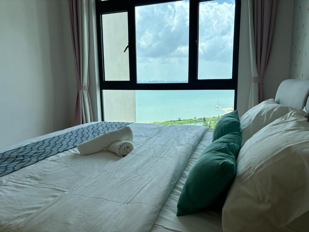 a large white bed with a window in a room at Seaview 2B2R 6pax Forest City C5-2404 in Gelang Patah