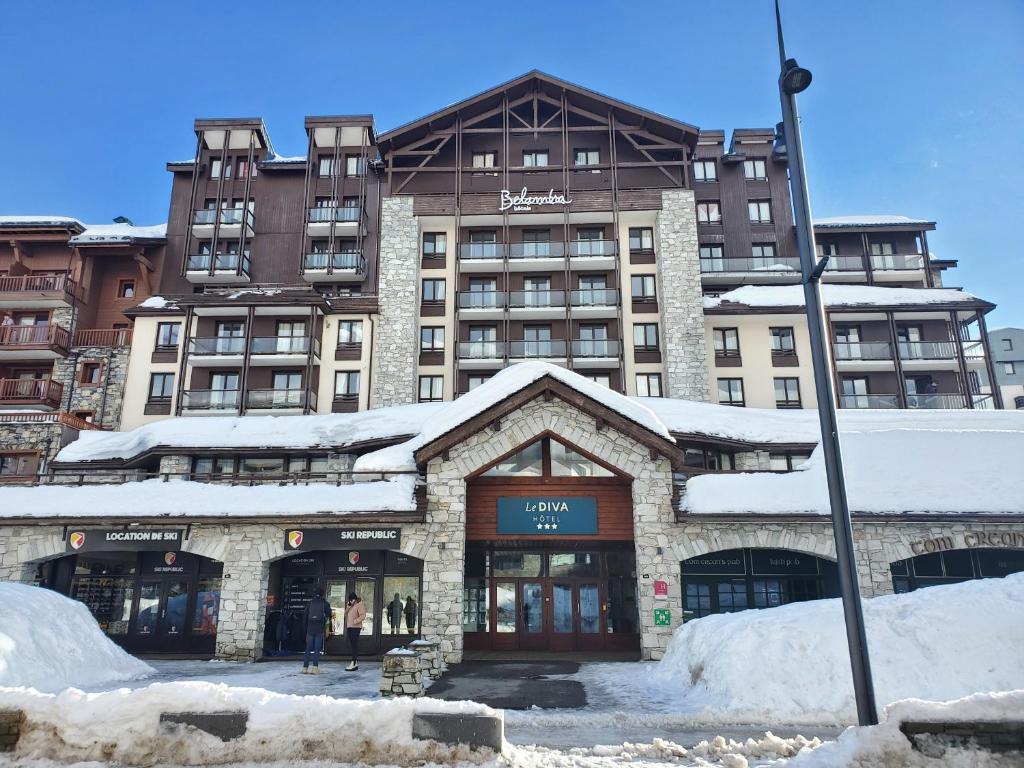 um grande edifício com neve em frente em Hôtel Tignes Le Diva em Tignes