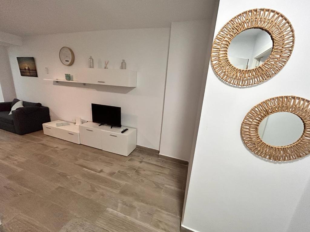 Biały salon z lustrem i telewizorem w obiekcie Apartamento Empul La Barrosa w mieście Chiclana de la Frontera