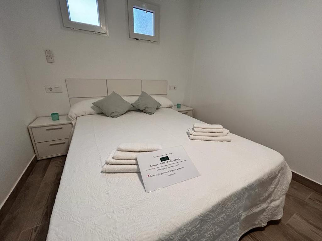 sypialnia z łóżkiem z ręcznikami w obiekcie Apartamento Empul La Barrosa w mieście Chiclana de la Frontera