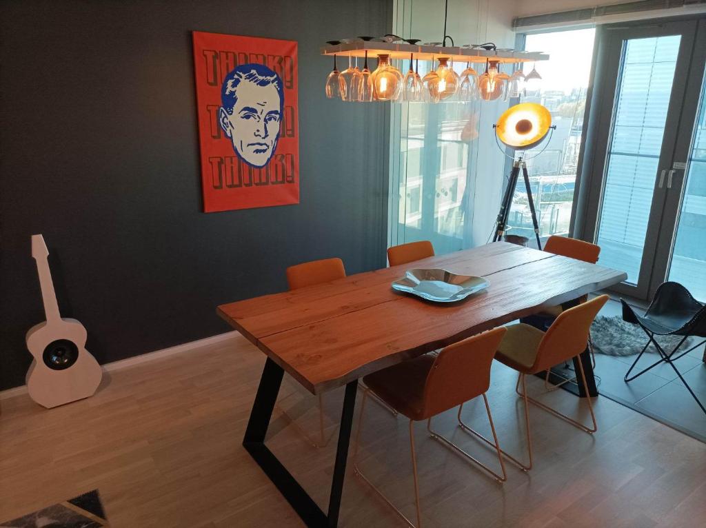 a dining room with a wooden table and chairs at Modern skyscraper apartment by metro and sea Helsinki in Helsinki