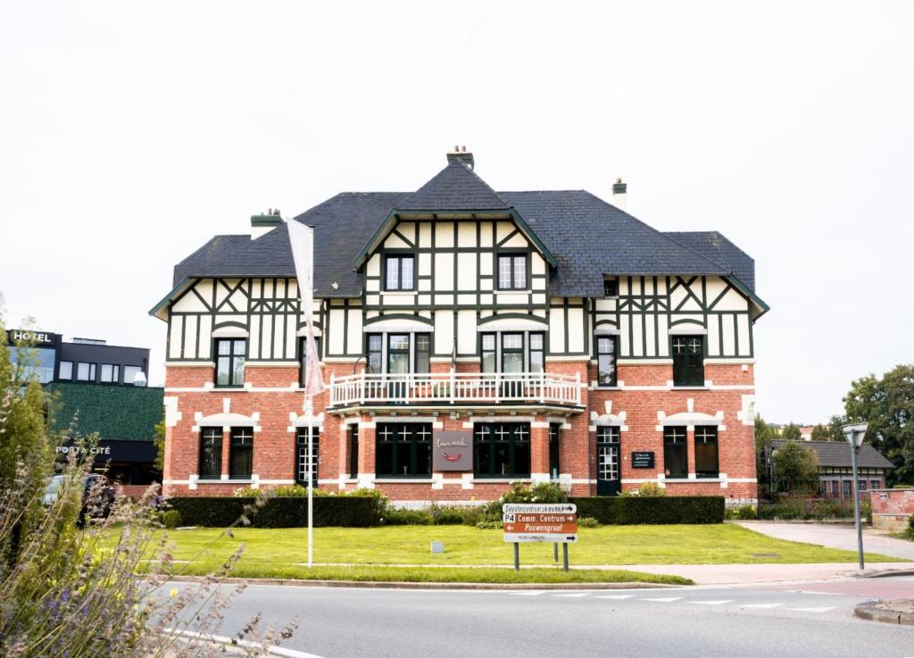 un grande edificio in mattoni con un cartello di fronte di Porta Cité a Maasmechelen