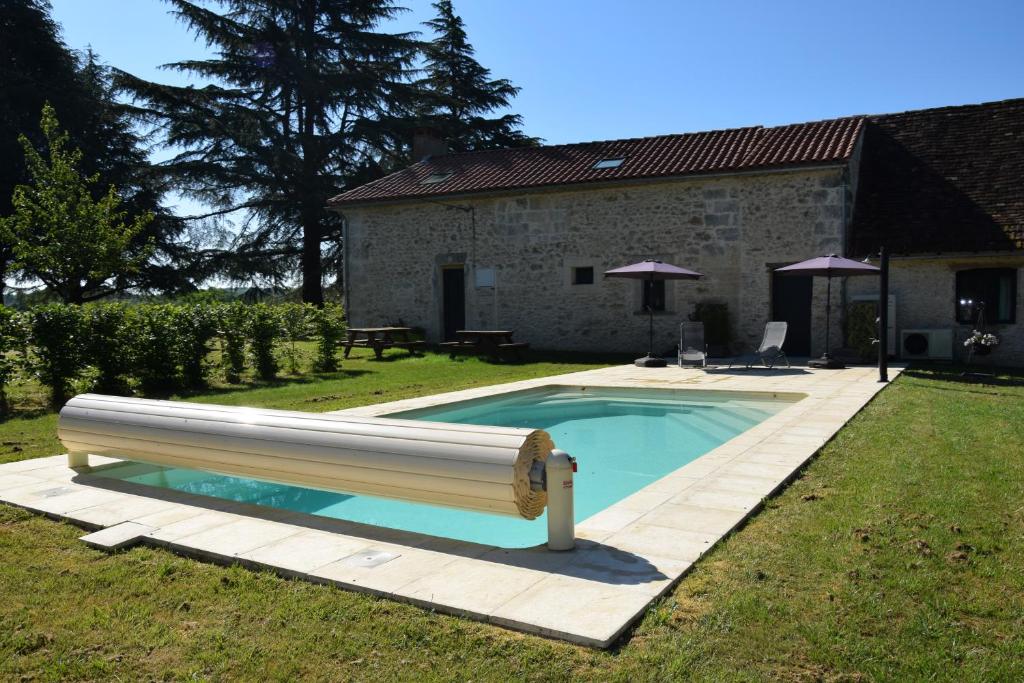 a swimming pool in the yard of a house at Gite Le Refuge des Ecureuils in Campsegret