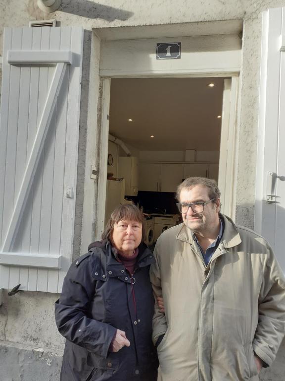 a man and woman standing in front of a house at NICOLAS ET MARIE in Courbevoie