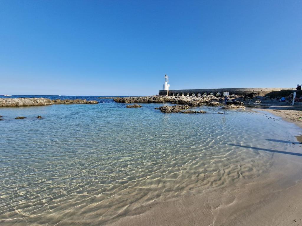 a beach with a lighthouse in the distance at Meraviglia d'Otranto in Otranto