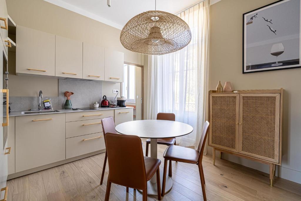 une cuisine et une salle à manger avec une table et des chaises dans l'établissement LE WINDSOR confortable pour un séjour au calme en centre-ville, à Cannes