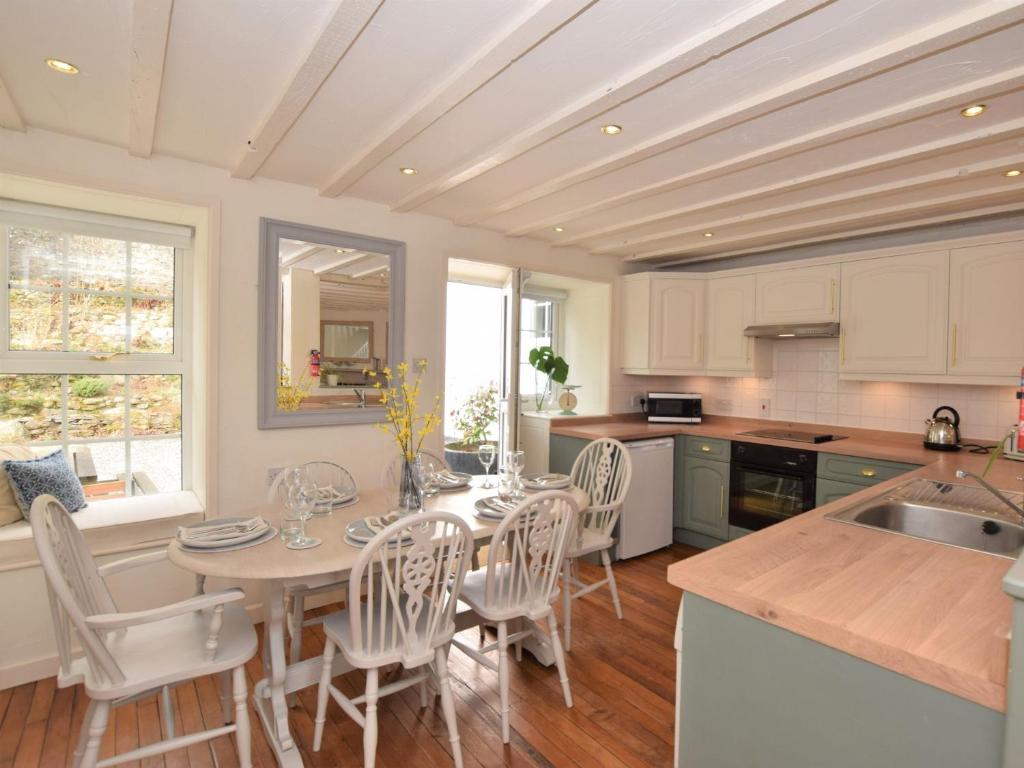 a kitchen with a table and chairs in a kitchen at 3 Bed in Conwy TYGOS in Llangelynin