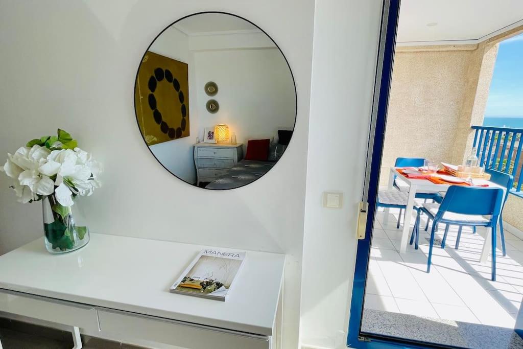 ein Spiegel auf einem Tisch mit einer Blumenvase in der Unterkunft Apto con vistas a la playa de La Patacona in Valencia