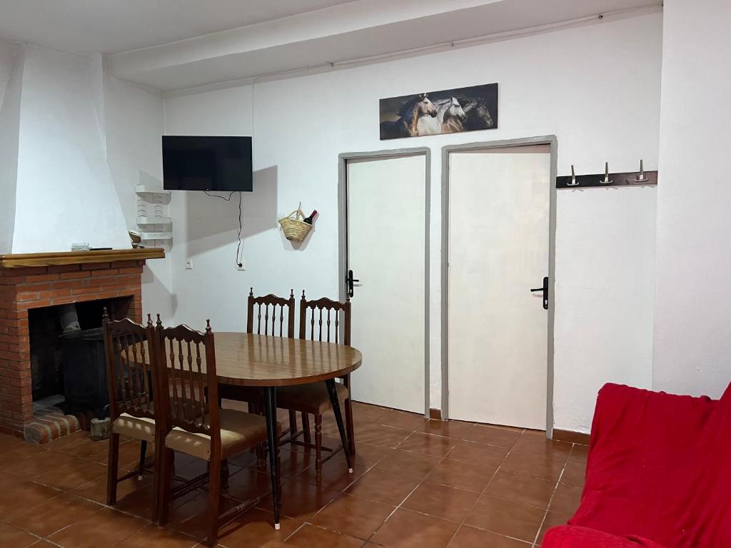 a dining room with a table and two doors at Casa Tita Maria in Trevélez