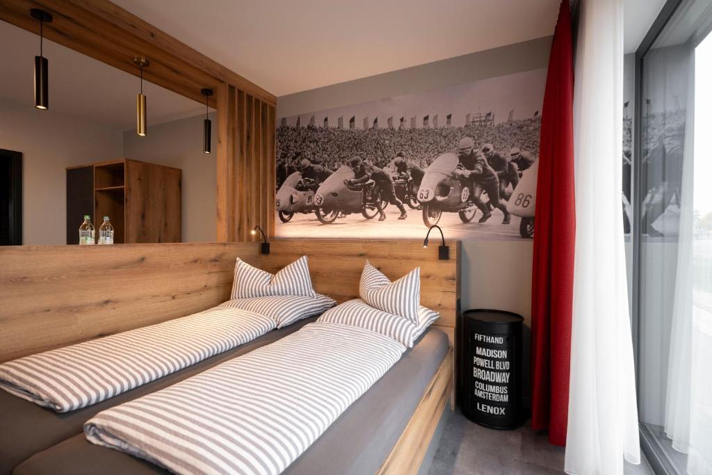 2 Betten in einem Zimmer mit Pferderennen an der Wand in der Unterkunft Quartier am Sachsenring in Oberlungwitz
