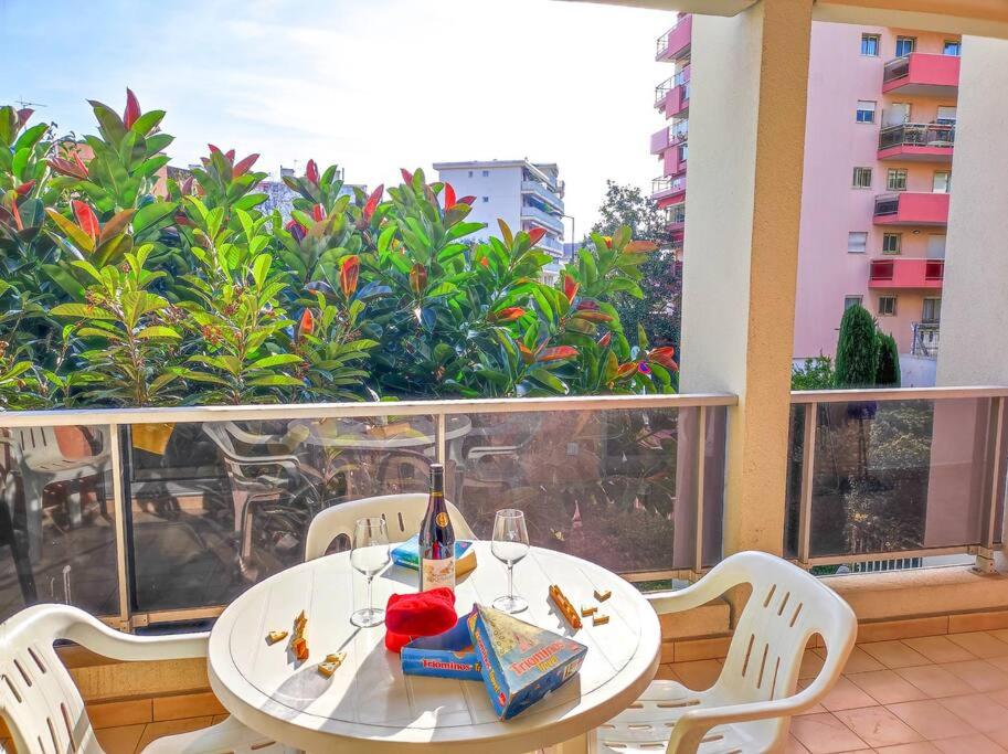 une table blanche et des chaises sur un balcon dans l'établissement Le Bradford YourHostHelper, à Cannes