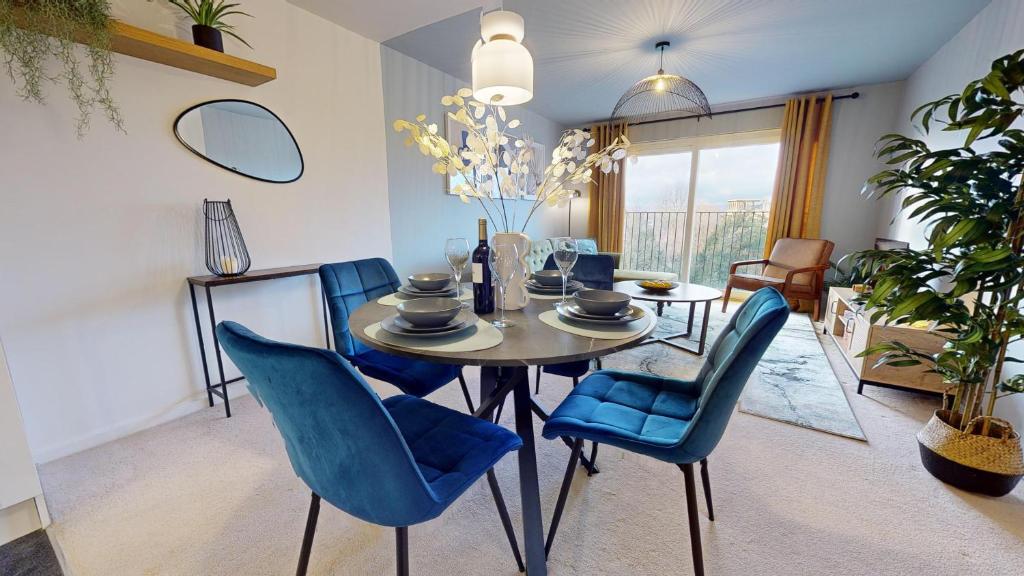 Stylish Central Apartment في بيكنهام: غرفة طعام مع طاولة وكراسي زرقاء