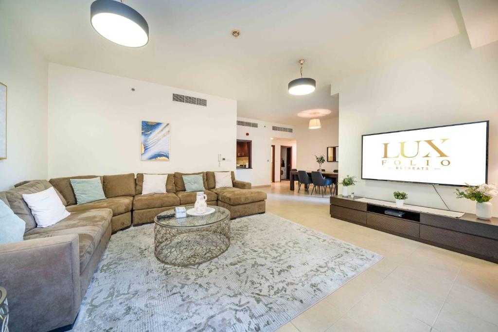 a living room with a couch and a tv at LUXFolio Retreats - Spacious 3 Bed - Marina Living in Dubai