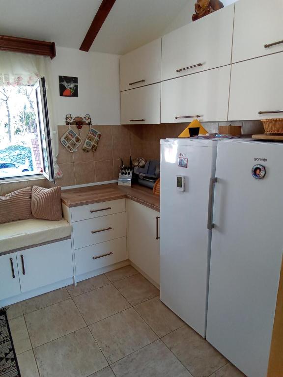 a kitchen with white cabinets and a refrigerator at Lux apartmani Darija in Kotor