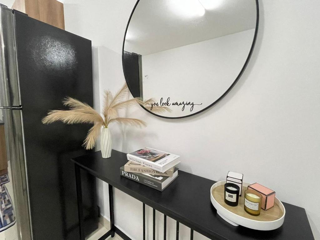 a mirror on a wall next to a black table at Myna Suite & Lenore at Alanis Residence Sepang, KLIA Homestay Apartment in Sepang