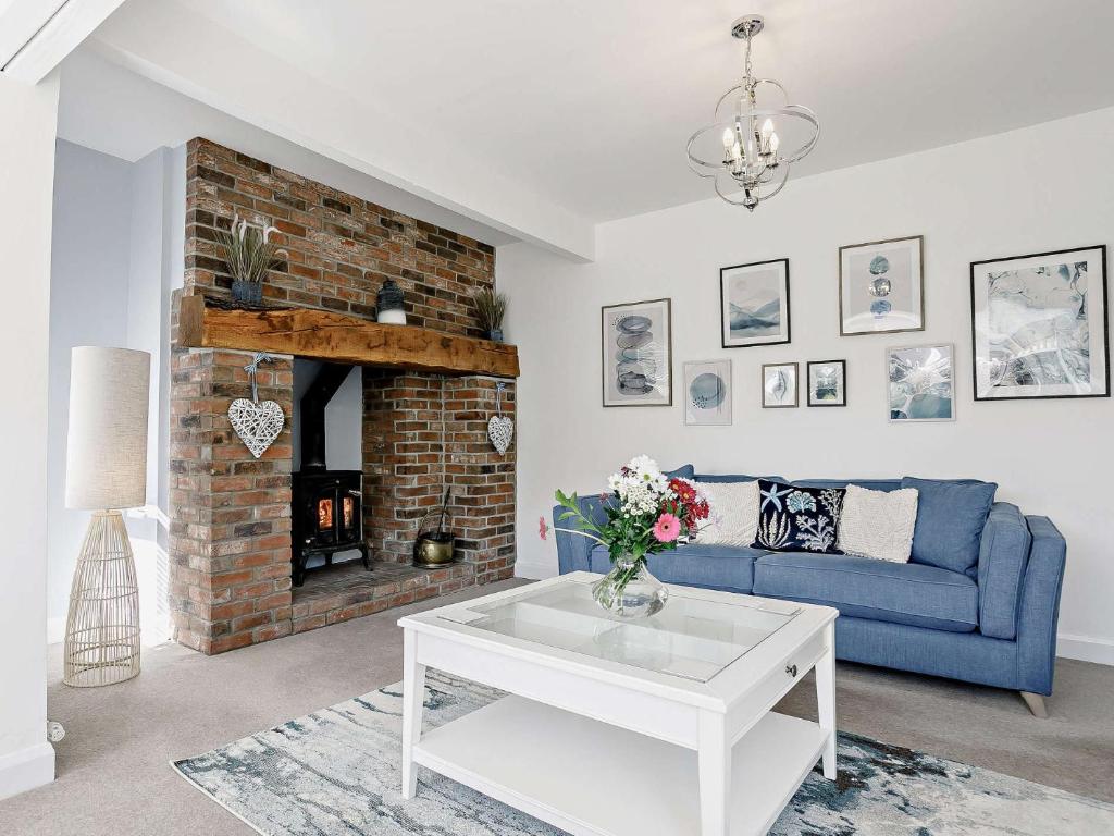 a living room with a blue couch and a fireplace at 3 Bed in Sutton on Sea SEALC in Sutton on Sea