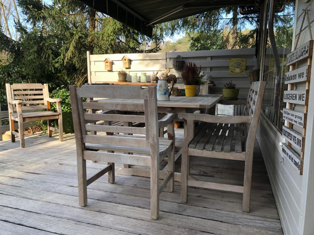 a wooden table and chairs on a deck at Chalet Relax in Zutendaal