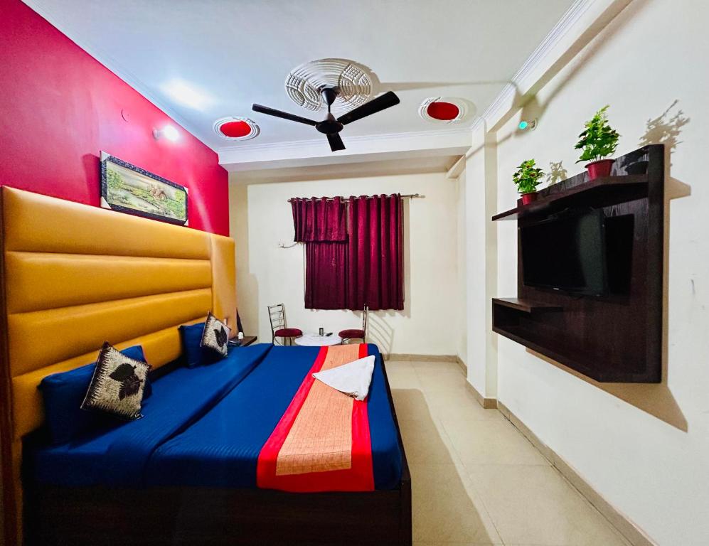 ニューデリーにあるHotel Aero Indus Near Airportのベッドルーム(青いベッド1台、テレビ付)