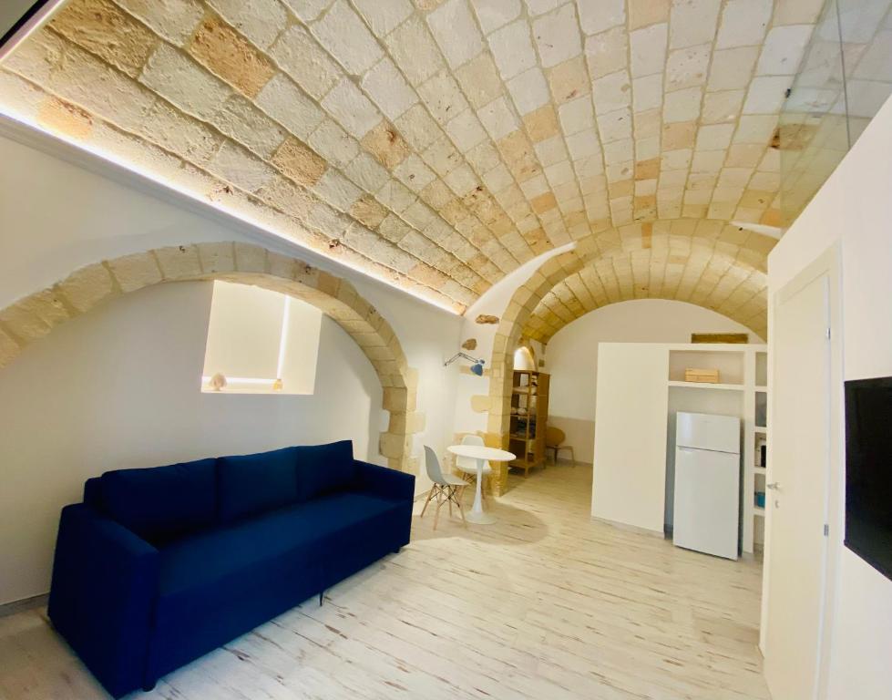 a living room with a blue couch and a stone ceiling at La Bitta Suite in Brindisi