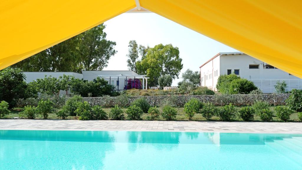 a view of a swimming pool from under a tent at TerreAmare Agriturismo in Porto Cesareo