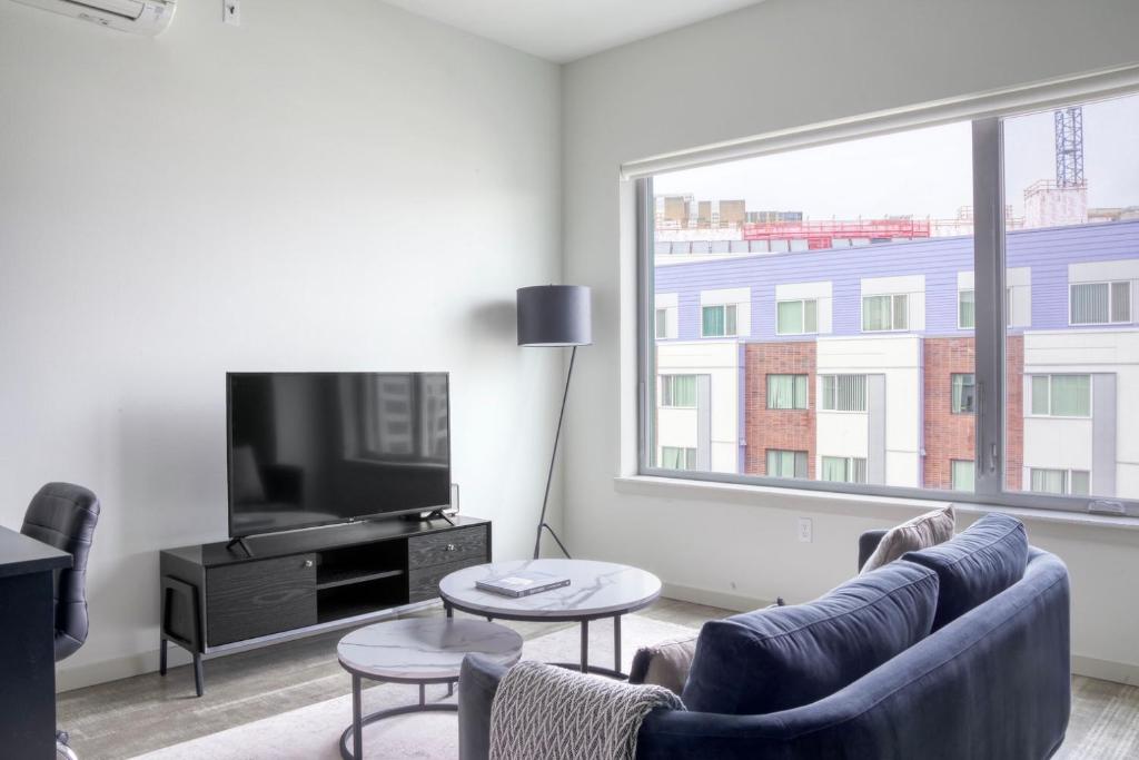 a living room with a couch and a tv and a window at Blueground First Hill gym nr green spaces SEA-707 in Seattle