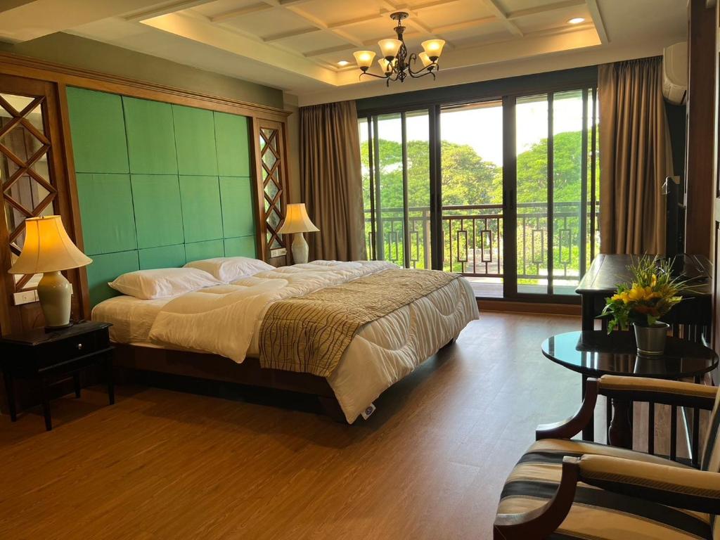 a bedroom with a large bed and a balcony at Quinstel Hostel in Bangkok