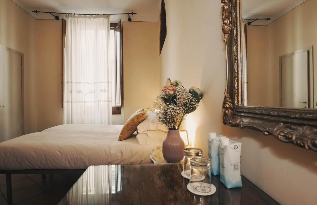una camera da letto con un letto con specchio e un tavolo di Hotel Galileo a Firenze