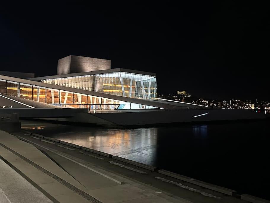 ein Gebäude mit einer Brücke über einen Fluss in der Nacht in der Unterkunft Luxurious apartment by Royal palace in Oslo