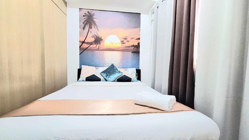 1 dormitorio con 2 camas y una pintura de puesta de sol en Stylish 1BR with Wifi and Queen size bed in Grace Res en Manila