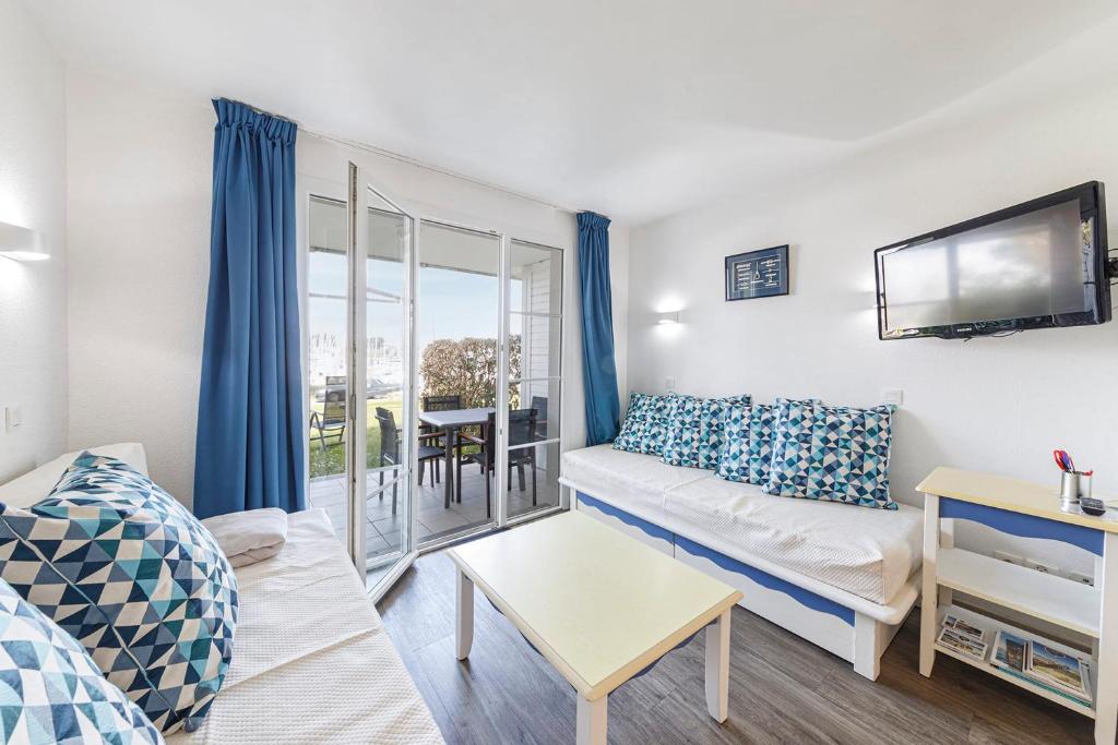 a living room with a couch and a tv at Charmant appartement vue sur le Crouesty in Arzon