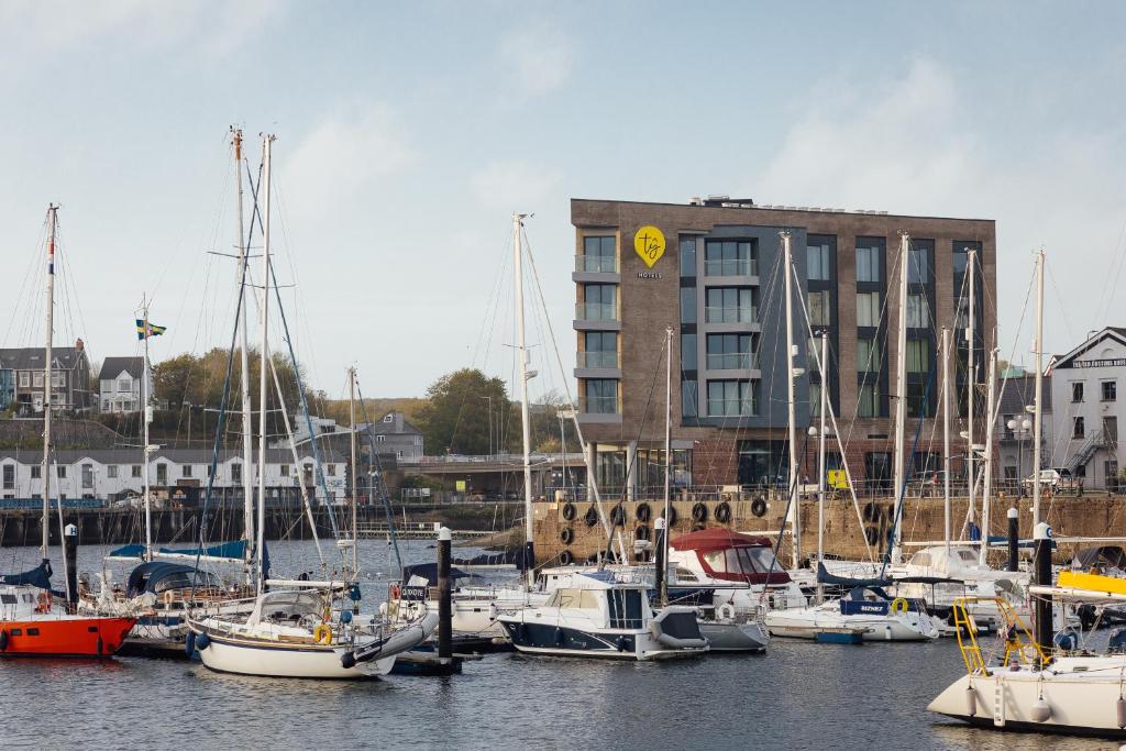 a group of boats docked in a harbor with a building at Tŷ Milford Waterfront in Milford Haven