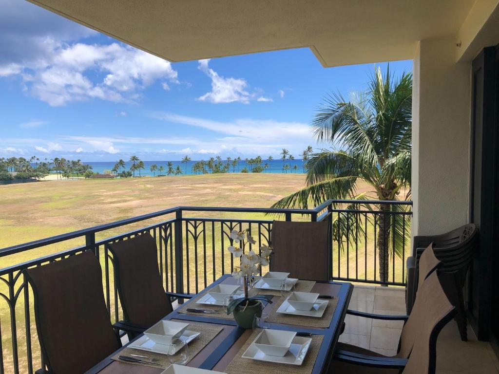 a table on a balcony with a view of the ocean at Ko Olina Beach Villas O425 in Kapolei