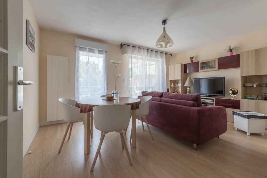 uma sala de estar com uma mesa e um sofá em LE VINTAGE - Appartement proche plage em Saint-Nazaire