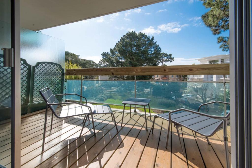 two chairs and a table on a deck with a view at LE DESIGN - Appartement vers la gare in La Baule