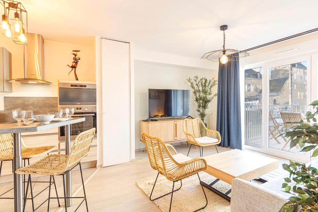 una cucina e un soggiorno con tavolo e sedie di La Kloserie appartement en résidence a Saint Malo