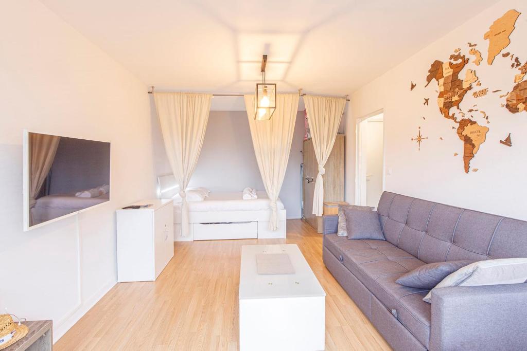 a living room with a couch and a bedroom at Studio spacieux proche gare in Angers