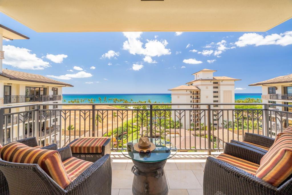 Un balcón con sillas y vista al mar. en Ko Olina Beach Villas O904, en Kapolei